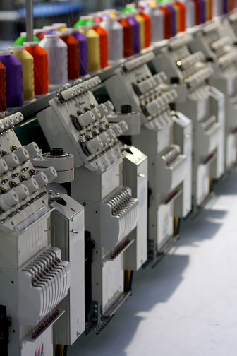 colorful yarn spools on an embroidery machine